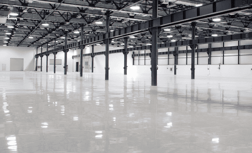 Large industrial space with a glossy epoxy floor, highlighting a smooth and reflective finish.