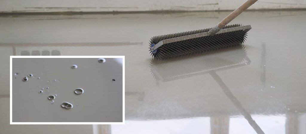 Close-up of epoxy floor showing surface bubbles due to installation errors